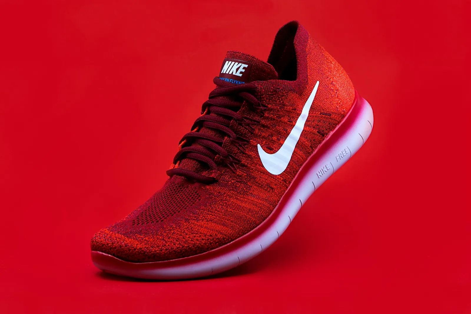 Red running shoe against a red background