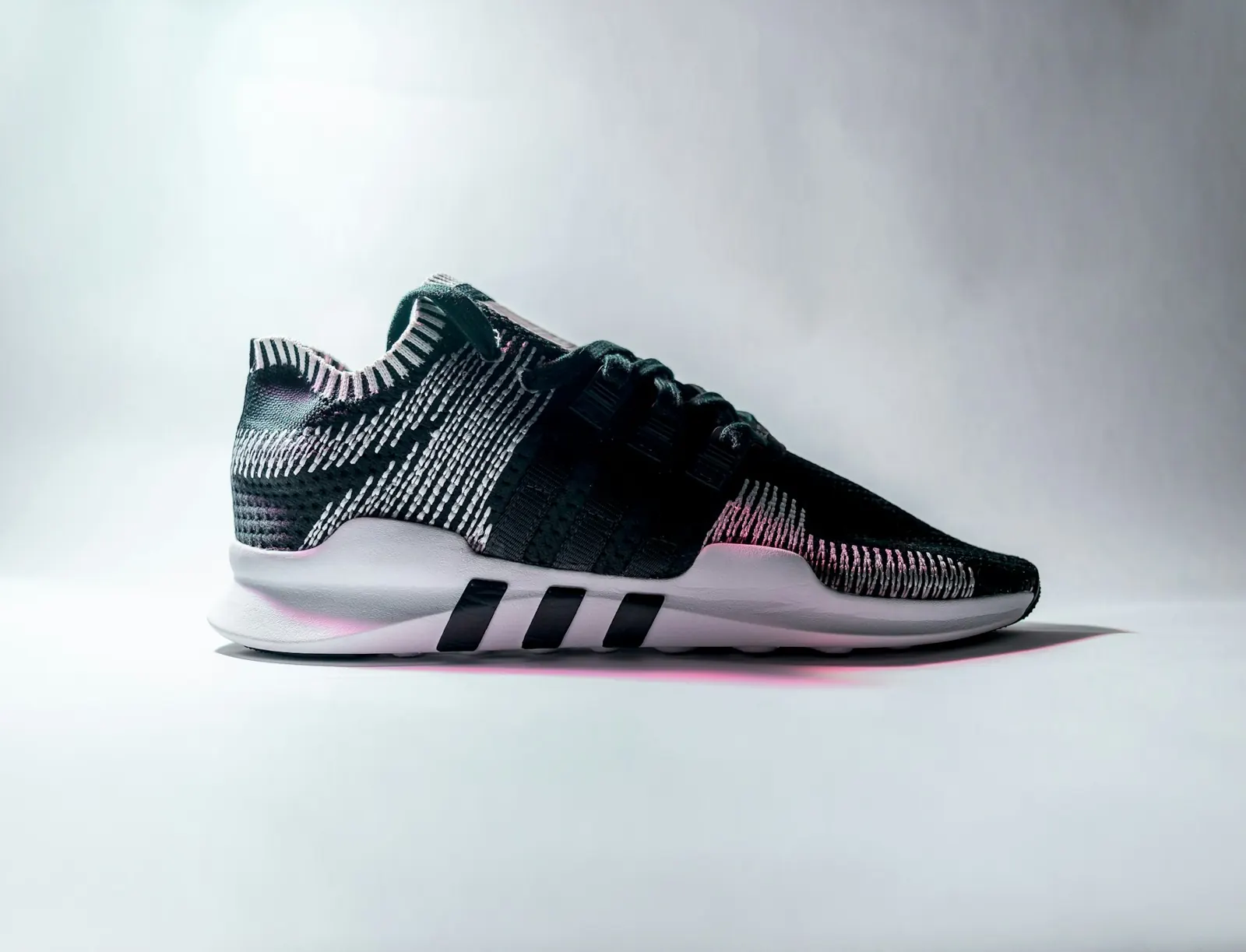 Grey and pink running shoe on a white background