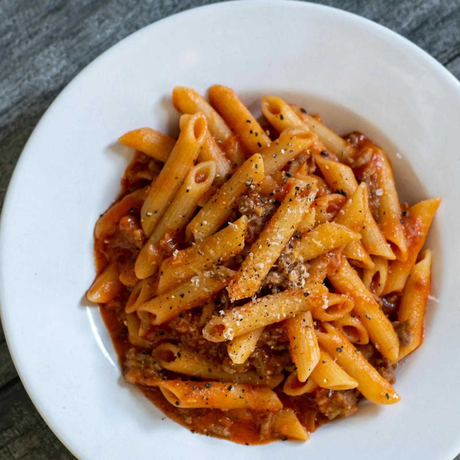 Plate of penne pasta with tomato sauce and cheese