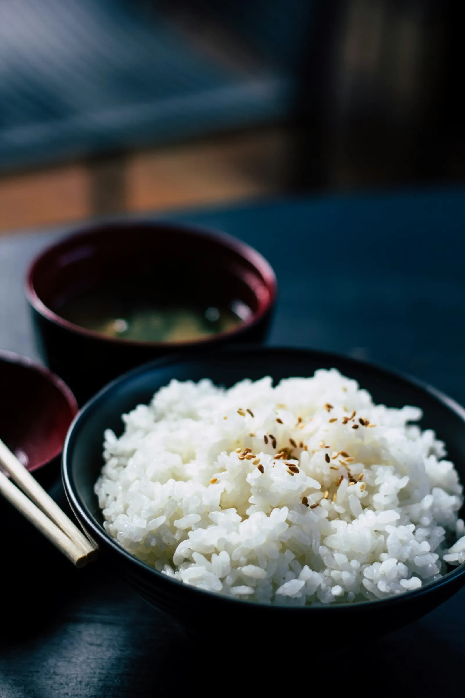 Bowl of white rice next to a cup of soup