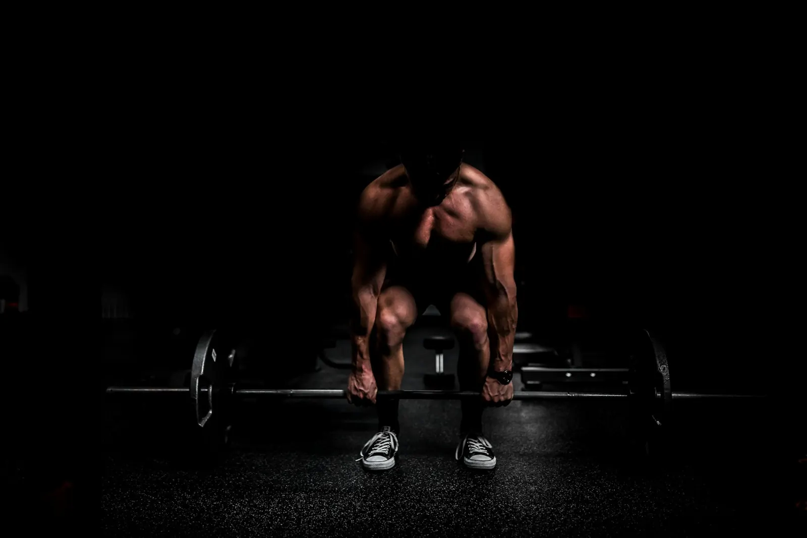 Athlete lifting a heavy barbell in a dimly lit gym