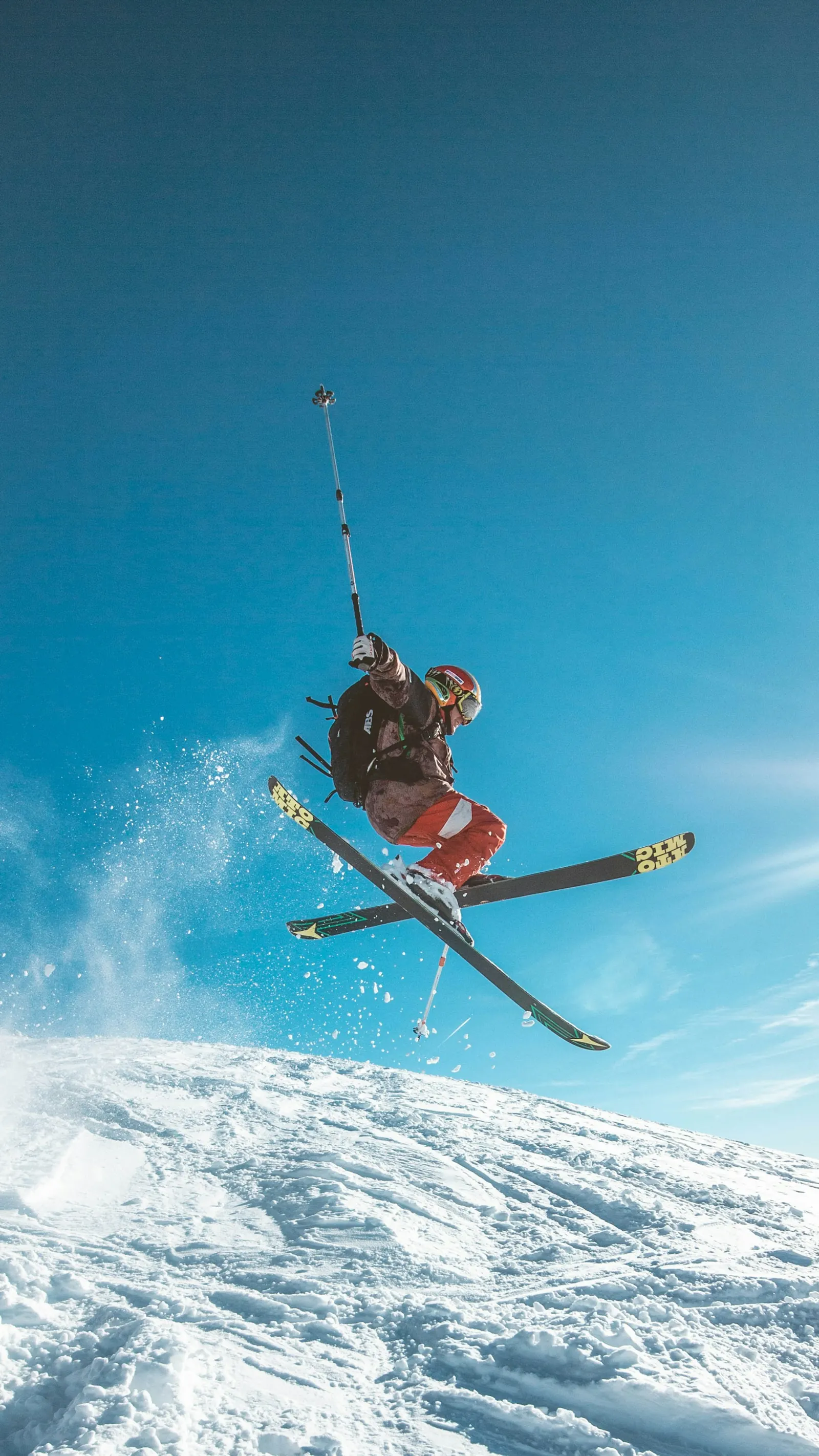 Freestyle skier in mid-air against a blue sky
