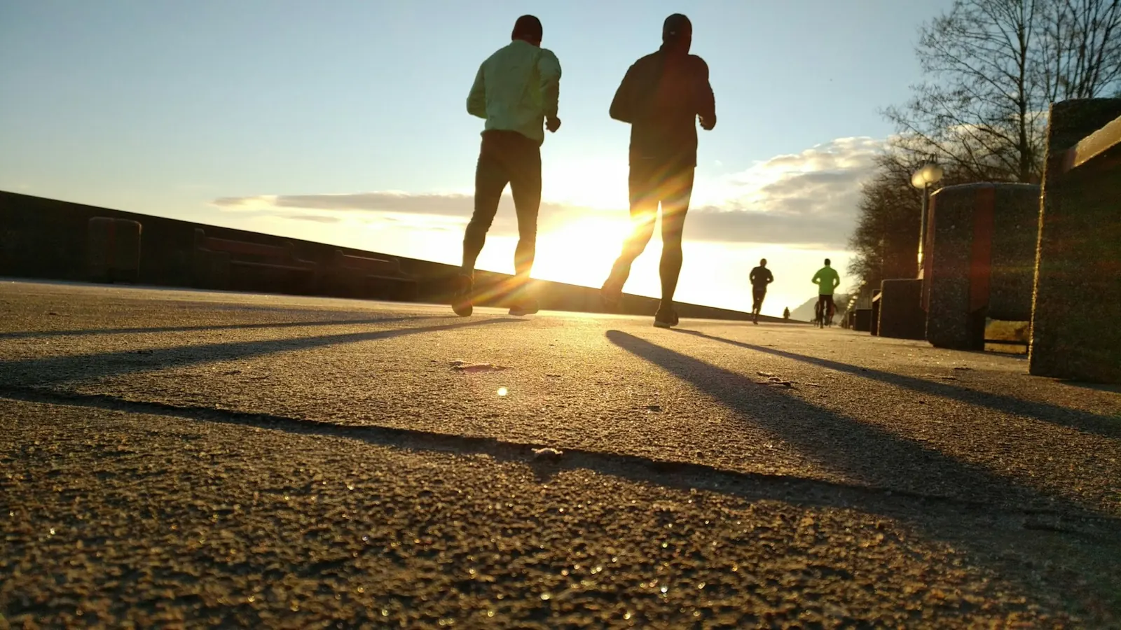 Two runners on a road at sunset