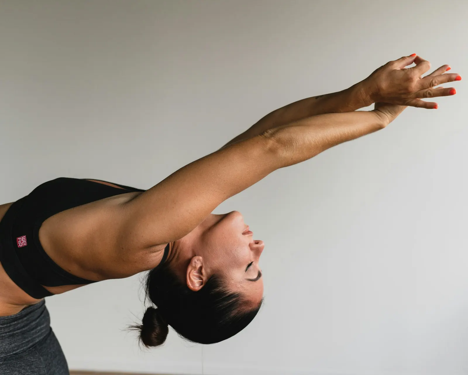 Woman leaning forward in a full-body stretch with arms reaching out