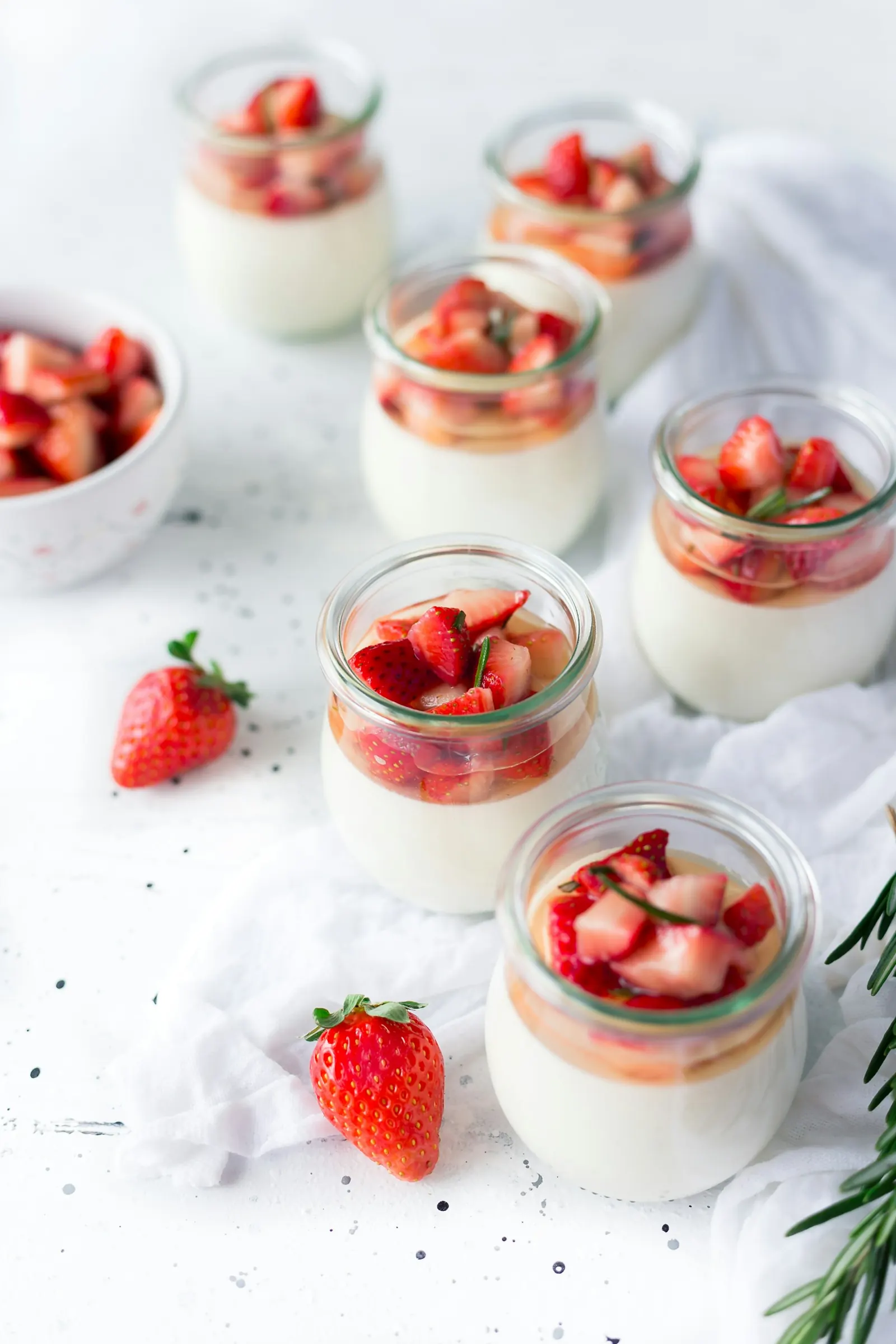 Small glass pots of yoghurt topped with strawberries