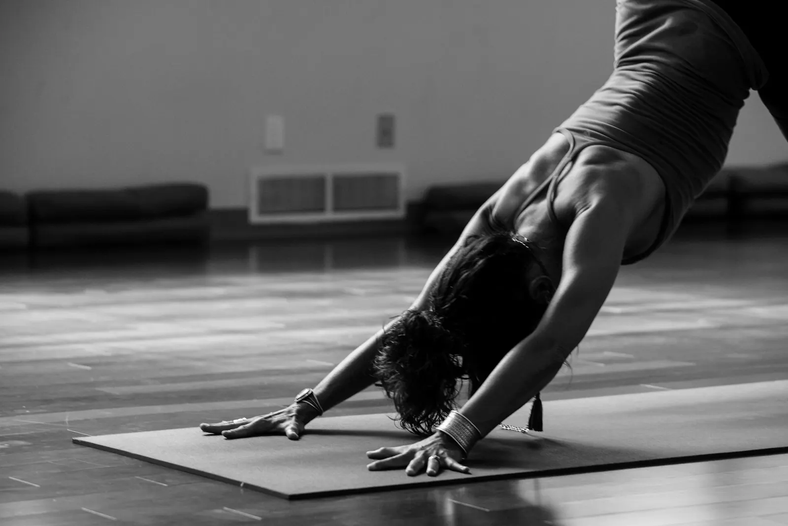 Woman in a downward dog stretch on an exercise mat in black and white
