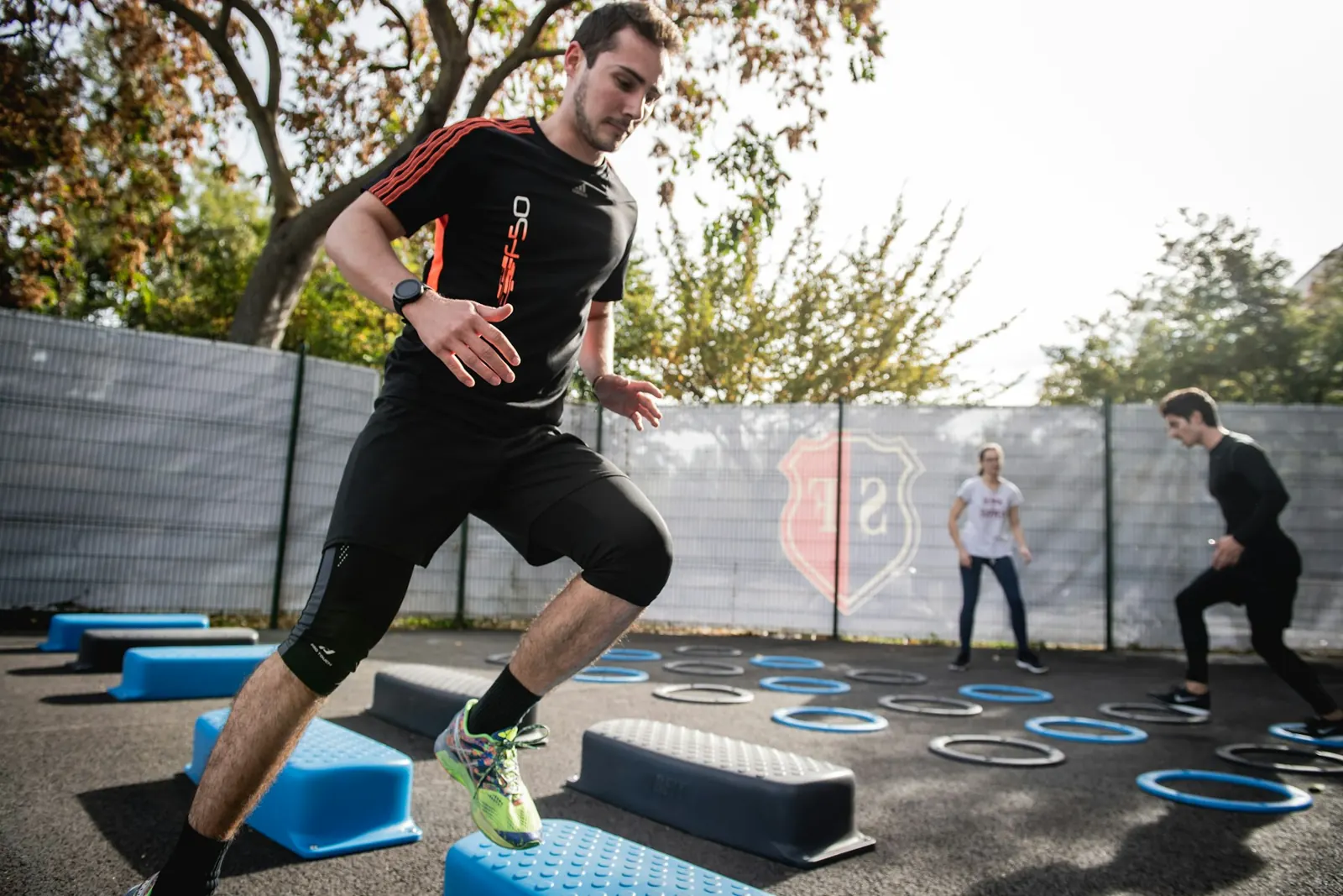 Man doing a lunge drill outdoors during a group training session