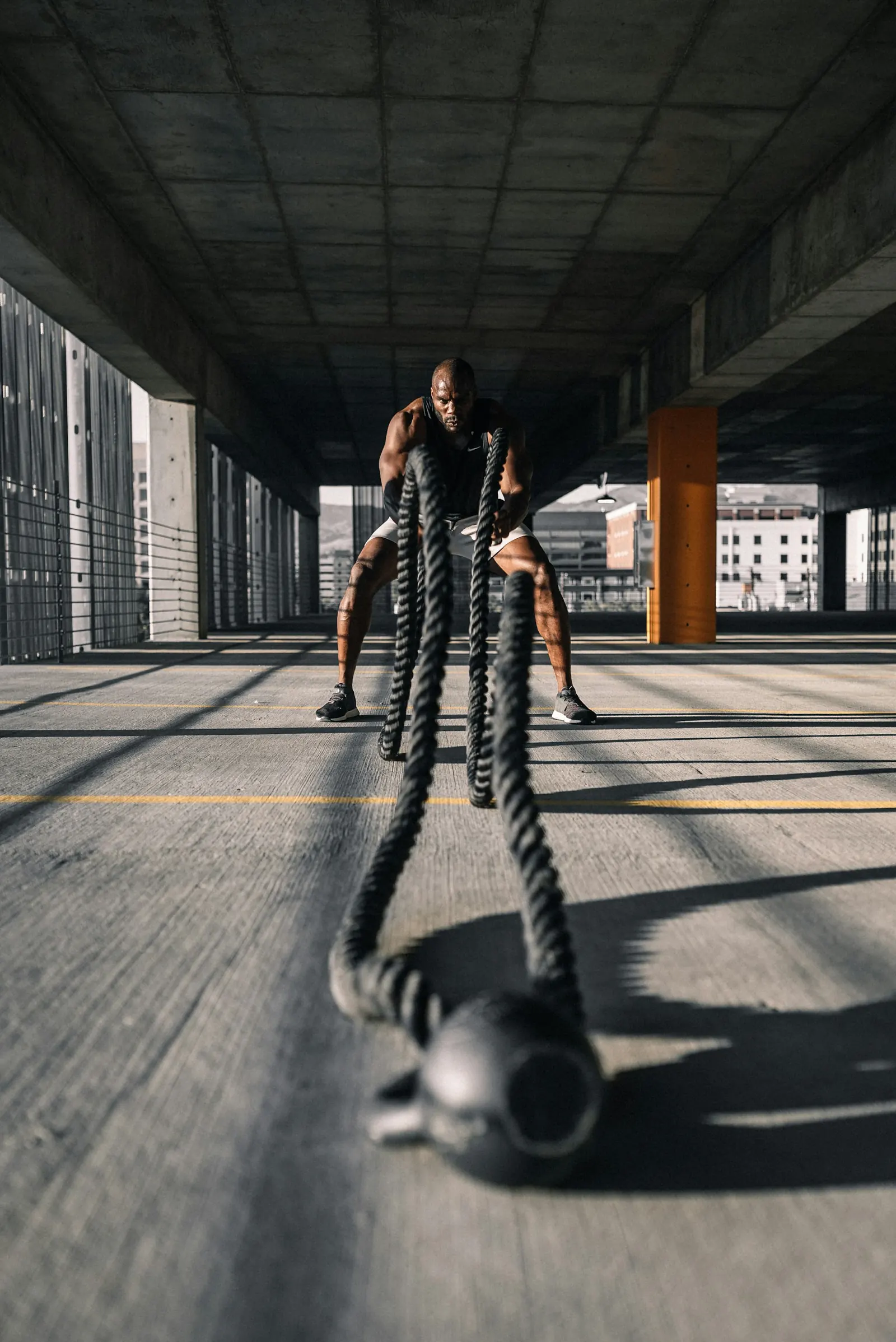 Athlete training with heavy battle ropes in an industrial gym